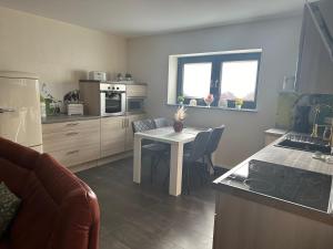 a kitchen with a white table and a kitchen with a counter at Ferienhaus Lübke Souterrain in Mühlhausen