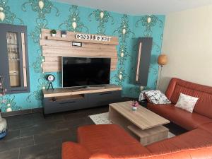 a living room with a couch and a flat screen tv at Ferienhaus Lübke Souterrain in Mühlhausen