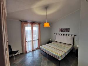 un dormitorio con una cama y una ventana en Appartamento Rosa di Chia, en Chia 6 fotos más