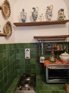cocina con azulejos verdes en la pared y fogones en Casetta Verde, en Tricarico