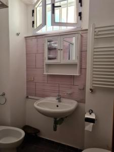 baño con lavabo y aseo y ventana en Casetta Verde, en Tricarico