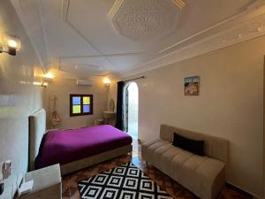 um quarto com uma cama roxa e um sofá em Villa C à 5km du centre em Marrakech