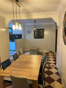 uma sala de jantar com uma mesa de madeira e cadeiras em Villa C à 5km du centre em Marrakech