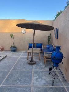 a patio with a table and an umbrella at Villa C à 5km du centre in Marrakesh