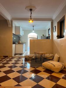 a living room with a table and a checkered floor at Villa C à 5km du centre in Marrakesh