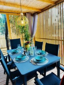 une table bleue avec des chaises et un lustre dans l'établissement Mobile Home ORANGE Camp Soline, à Biograd na Moru
