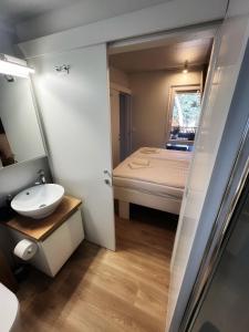 - une petite salle de bains avec un lavabo et un lit dans l'établissement Mobile Home ORANGE Camp Soline, à Biograd na Moru