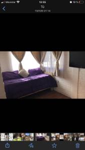 een slaapkamer met een paars bed en een raam bij Casa amoblada hasta 3 personas in Merlo