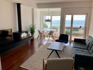 a living room with a couch and a table with chairs at Oceanview 4 U - Close to Lisbon! in Oeiras