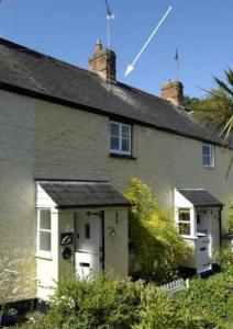 a small white house with a white door at Lime Cottage in Minehead