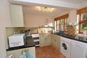 a kitchen with a washer and dryer in it at Lime Cottage in Minehead