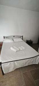a white bed with two white towels on it at ANASA in Ios Chora