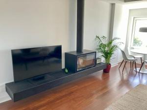 a living room with a large flat screen tv at Oceanview 4 U - Close to Lisbon! in Oeiras