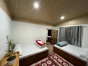 a room with two beds and a window at Orange Bari Farmstay in Darjeeling