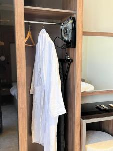 a robe hanging on a rack in a bedroom at لافانتا للشقق المخدومه - LAVANTA Hotel in Al Khobar