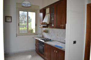 kuchnia z kuchenką i oknem w obiekcie Villa Melina w Syrakuzach