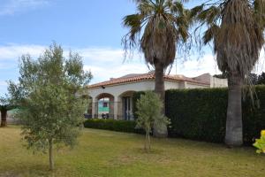 dom z dwoma palmami przed nim w obiekcie Villa Melina w Syrakuzach