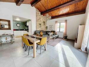 uma sala de estar com uma mesa e cadeiras amarelas em Villa avec piscine em Montpellier