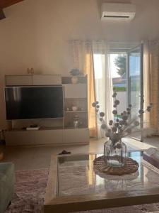 uma sala de estar com uma televisão e uma mesa de vidro em Villa avec piscine em Montpellier