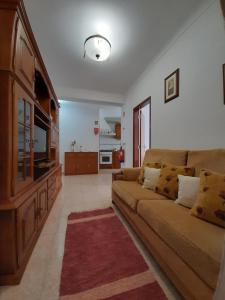 un soggiorno con un divano e una televisione di Lugar do Sonho Apartamento a Cercal