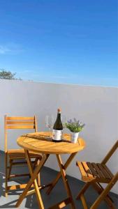 un tavolo in legno con una bottiglia di vino e due bicchieri di Lugar do Sonho Apartamento a Cercal