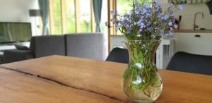 un vaso pieno di fiori viola seduto su un tavolo di Pod Beskydem, Velké Karlovice a Velké Karlovice