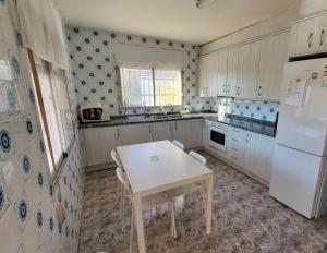 a kitchen with a table and a white refrigerator at villa berta in Vinarós