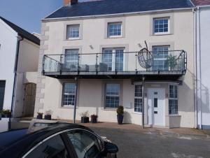 a white house with a balcony on top of it at Private Quay, Balcony, Sea Views, Free Parking in Pembrokeshire