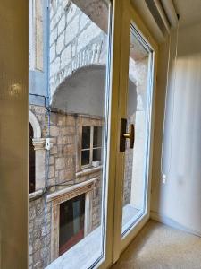 uma porta de vidro com uma lareira de tijolos num quarto em Apartment Zakrjan in Old town Korčula em Korčula