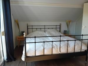 a bedroom with a bed with white sheets at Vakantiehuis vlakbij Duitse grens in Beek
