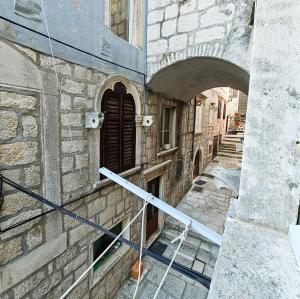 een steegje met een deur en een boog op een gebouw bij Apartment Zakrjan in Old town Korčula in Korčula