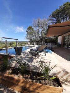 un patio avec un banc et une piscine dans l'établissement Maison au pied de la st victoire avec piscine, à Pourrières