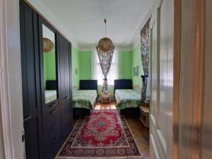 een kamer met groene muren en een rood tapijt bij Етаж от къща с двор in Boergas