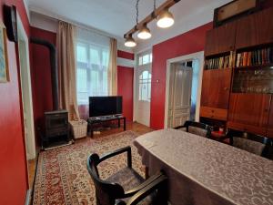 een eetkamer met rode muren en een tafel en stoelen bij Етаж от къща с двор in Boergas