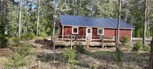 eine rote Hütte mitten im Wald in der Unterkunft Davids Stuga in Klässbol