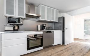 a kitchen with white cabinets and stainless steel appliances at Nachtstern in Zinnowitz