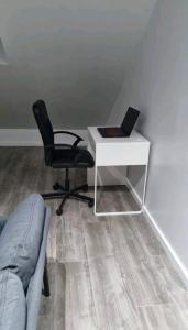 escritorio con silla y ordenador portátil en Bright and cozy room close to airport en Kampenhout