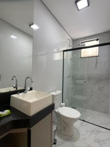 La salle de bains est pourvue d'un lavabo, de toilettes et d'une douche. dans l'établissement Luxo colado no Shopping, à Franca