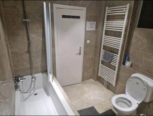 y baño con ducha, aseo y bañera. en Bright and cozy room close to airport en Kampenhout