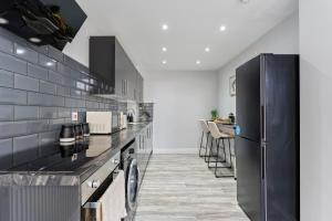 a kitchen with black appliances and a black refrigerator at Harwich Luxury Suite in Harwich