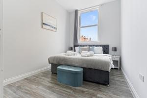 a white bedroom with a bed and a window at Harwich Luxury Suite in Harwich