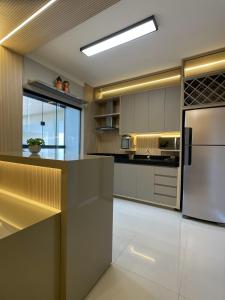 a kitchen with stainless steel appliances and a refrigerator at Luxo colado no Shopping in Franca