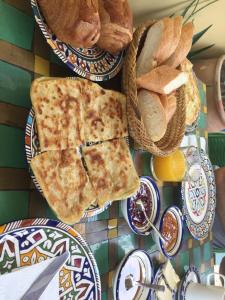una mesa con platos de pan y rebanadas de pizza en Hostel Speakeasy Fes, en Fez