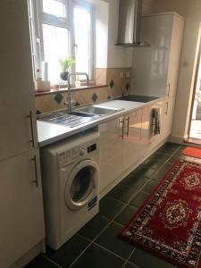 a kitchen with a washing machine and a sink at Modern Bromely House in BR5 in Foots Cray