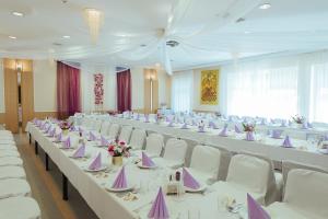 un salón de banquetes con mesas blancas y sillas blancas en Hotel Pod Sosnami, en Osieck