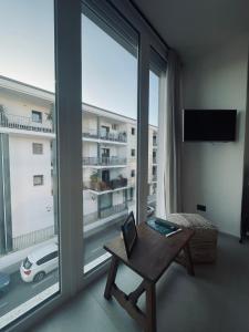 Una sala de estar con una mesa y una gran ventana. en Casa Amerì affittacamere, en Olbia