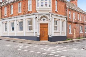 a large brick building with a wooden door on a street at Harwich Luxury Suite in Harwich