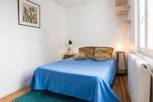 a bedroom with a blue bed with a blue blanket at Les Jardins suspendus in Angoulême
