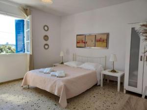 a white bedroom with a bed with towels on it at The house of Nikos and Katerina 2 in Andros