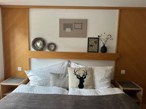 Bett mit einem hölzernen Kopfteil mit einem Hirschaufkleber darauf in der Unterkunft Apartment Bergfreude in Saas-Grund